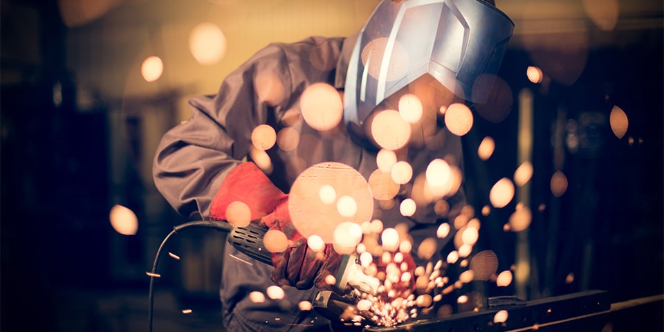 Employee grinding steel with sparks